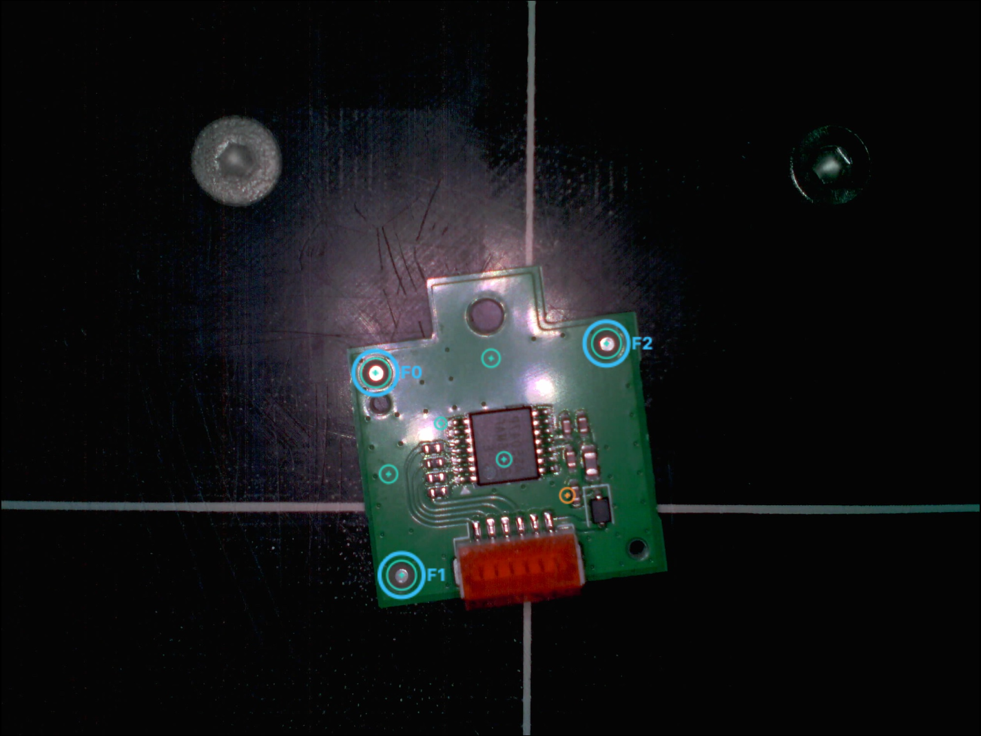 The camera's top-down view of a small green PCB on the dark machine bed, with three fiducials circled in cyan and labelled F0, F1 and F2, other pads ringed in teal, and a white crosshair marking the machine origin.